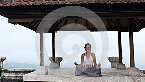 Woman meditating and doing yoga in abandoned temple. Female practicing pose