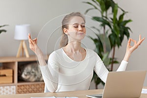 Woman meditating doing yoga sitting at workplace