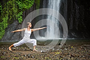 Woman meditating doing yoga between waterfalls