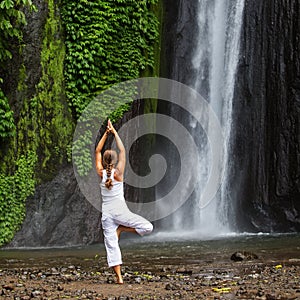 Woman meditating doing yoga between waterfalls