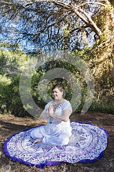 Woman meditating in the forest