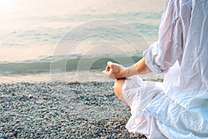 Woman meditating at the Garda Lake. Sunset.