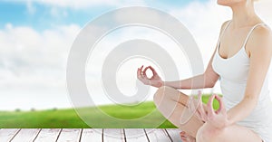 Woman Meditating by green field and sky