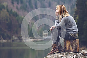 Woman meditating on a lake shore