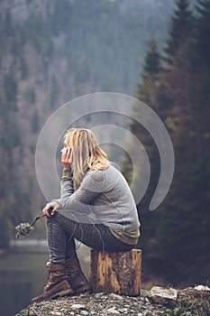 Woman meditating on a lake shore