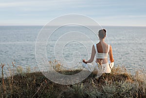 Woman meditating near sea. Space for text