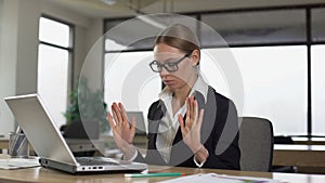 Woman meditating at office desk, reducing work stress and irritation, relaxing