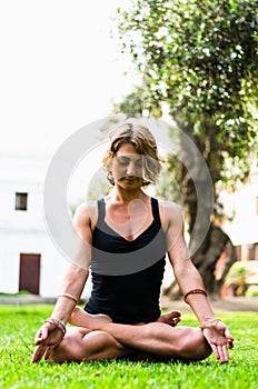 Woman Meditating And Practicing Yoga, Padmasana. Meditation On Sunny Autumn Day At Park. Workout Outdoor.