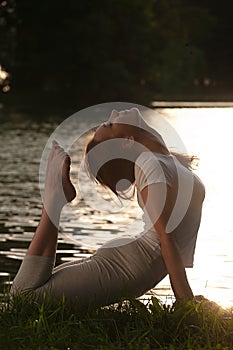 Woman meditating practicing yoga in park.