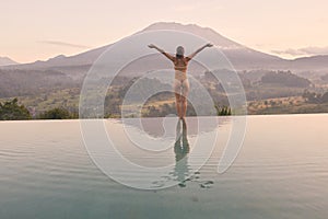 Woman Meditating at Resort Pool in Bali Agung Volcano - Best Travel Destination