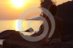 Woman meditating on sea beach