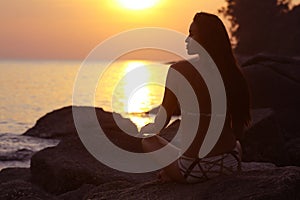 Woman meditating on sea beach