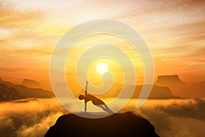 Woman meditating in side balance yoga position on the top of a mountains