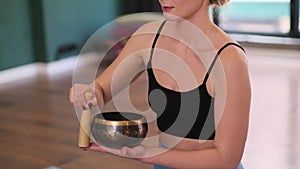 woman meditating with sounds of a Tibetan singing bowl and standing bell as part of her meditation