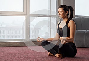 Woman meditating in sukhasana yoga pose.