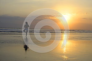 Woman meditating and thinking peacefully in yoga pose on desert beach on sunset in meditation and freedom
