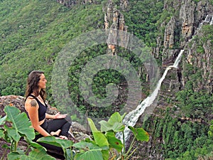 Woman meditating on top of a mountain