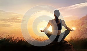 Woman meditating yoga at sunset mountains with nature. Outdoor s photo