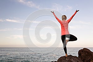 Woman meditating in yoga vrksasana tree pose