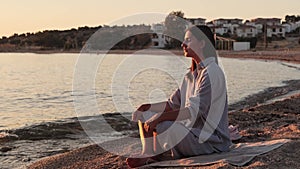Woman meditating, zen yoga meditation practice breath exercise in nature. Yogi girl is sitting in sunset, healthy