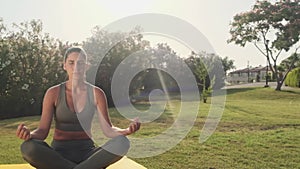 Woman meditating, zen yoga meditation practice in nature. Yogi girl is sitting in lotus pose, healthy lifestyle