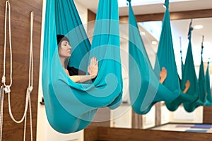 Woman meditation in hammock. fly yoga stretching exercises in gym. Fit and wellness lifestyle