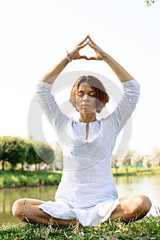 Woman in meditation pose. The hands are places above the head photo