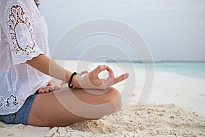 woman in meditation posture by the sea