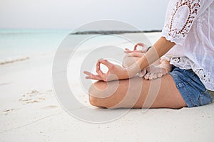 woman in meditation posture by the sea