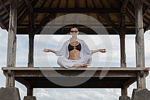 A woman in a meditative yoga pose in a Balinese pavilion, creating a picture of tranquility and balance Tranquil Yoga Pose photo