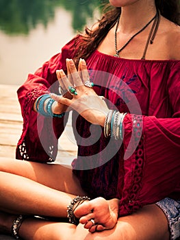 Woman in a meditative yoga position by the lake