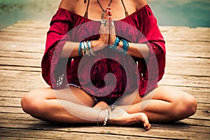 Woman in a meditative yoga position by the lake