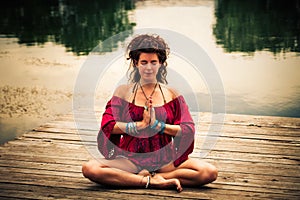 Woman in a meditative yoga position by the lake photo
