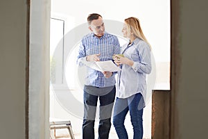 Woman Meeting With Architect Or Builder In Renovated Property