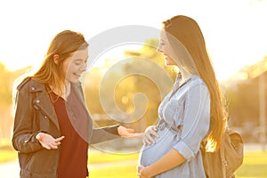 Woman meeting her pregnant friend in a park