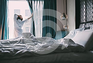 Woman meets rainy morning in luxus hotel room photo