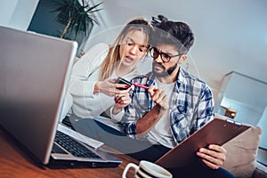 Woman and man doing paperwork together, paying taxes online