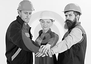 Woman and men in hard hats holds hands together. Team of architects, builders ready to work, isolated white background.