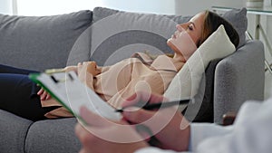 Woman with mental health problem after covid 19 lying on couch talking therapist