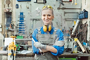 Woman metalworker with tool posing for the camera photo