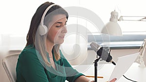 Woman with microphone recording podcast at studio