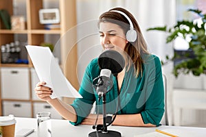 Woman with microphone recording podcast at studio