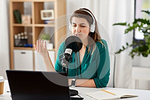 Woman with microphone recording podcast at studio