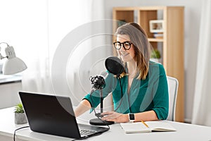 Woman with microphone recording podcast at studio