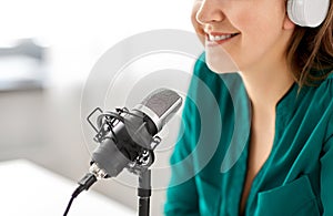 Woman with microphone recording podcast at studio