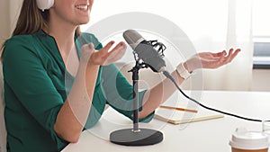 Woman with microphone recording podcast at studio