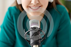 woman with microphone recording podcast at studio