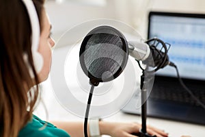 woman with microphone recording podcast at studio