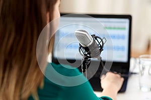 woman with microphone recording podcast at studio