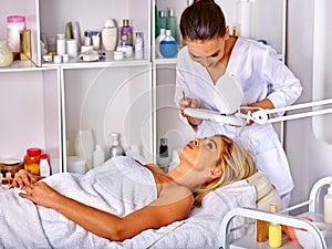 Woman middle-aged lying in spa salon. Tweezing eyebrow beautician.